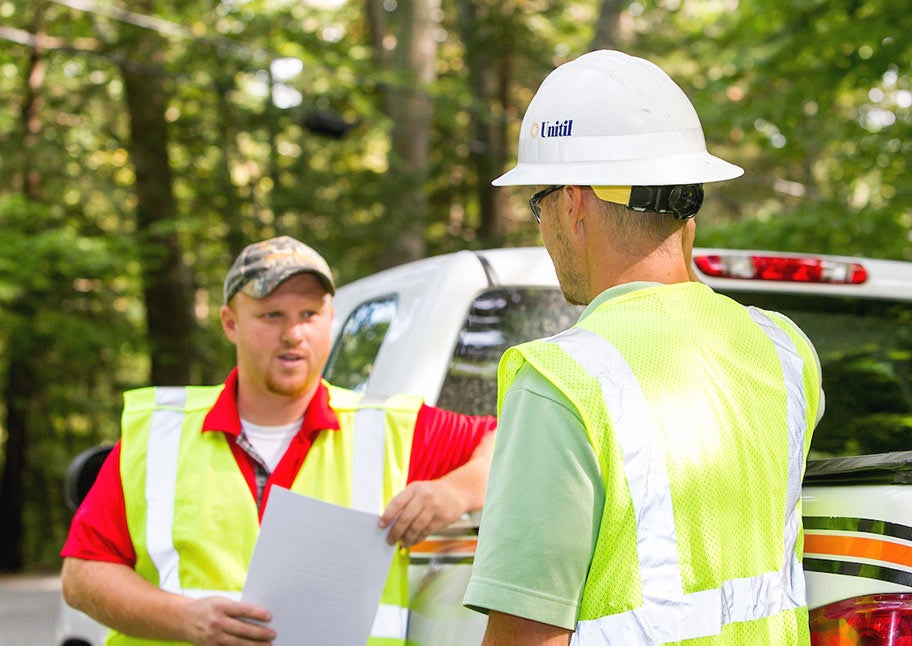 Unitil tree crew talking by truck