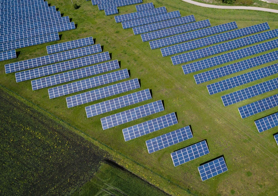 Aerial image of a solar array in a green field.