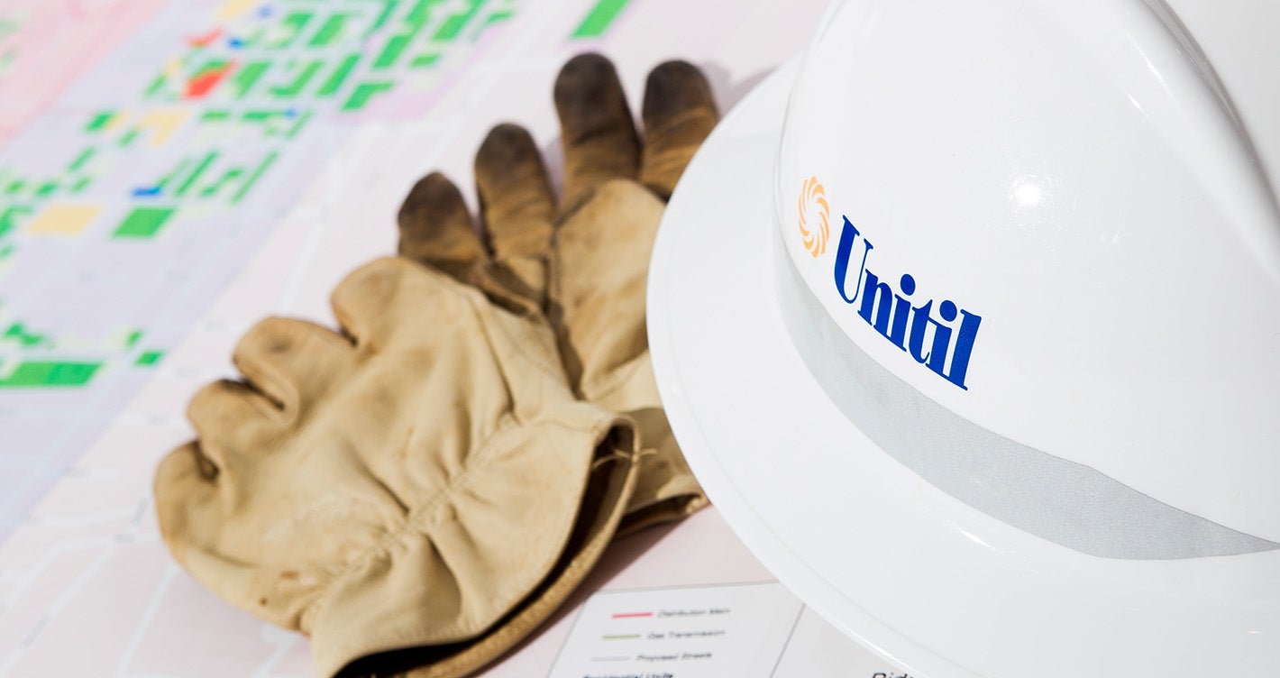 Unitil hard-hat and work gloves placed on top of a map