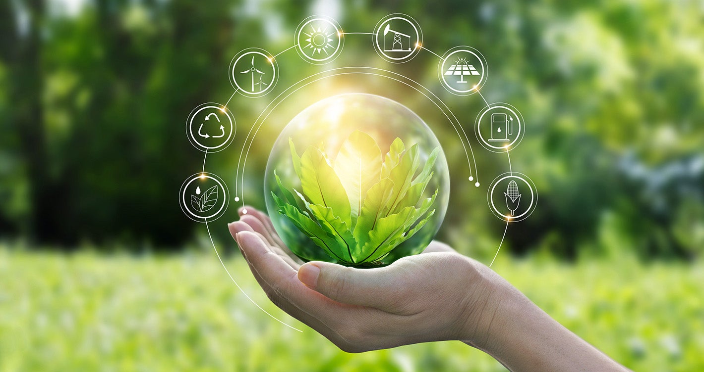 Hand in a green field holding a green orb surrounded by renewable energy icons