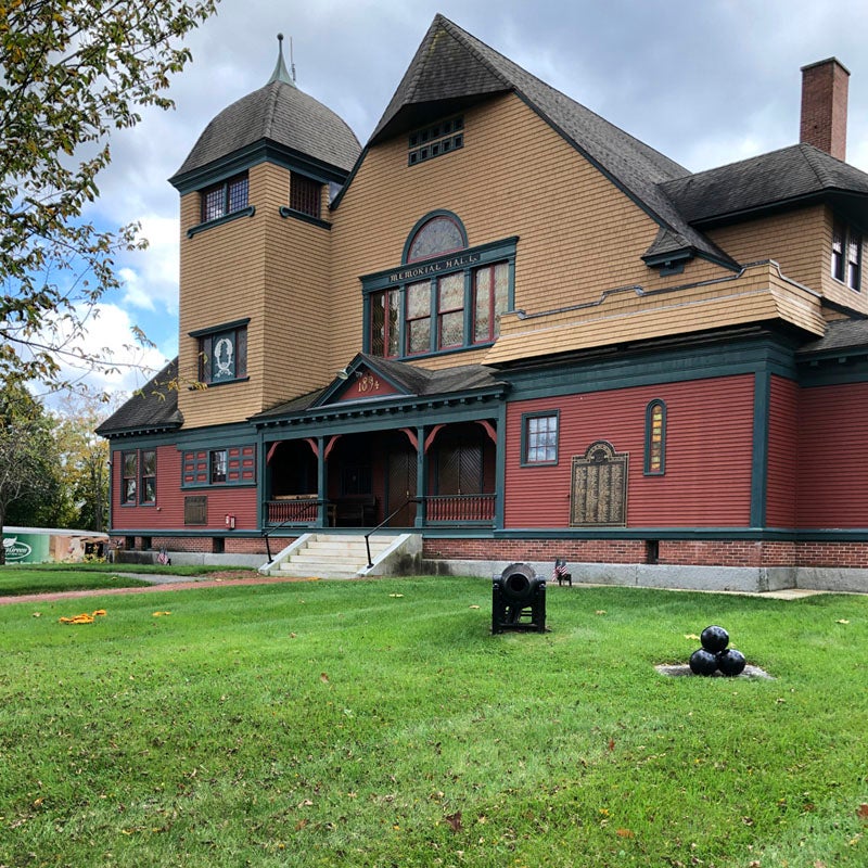 red and brown exterior of Townsend Memorial Hall with green lawn in front