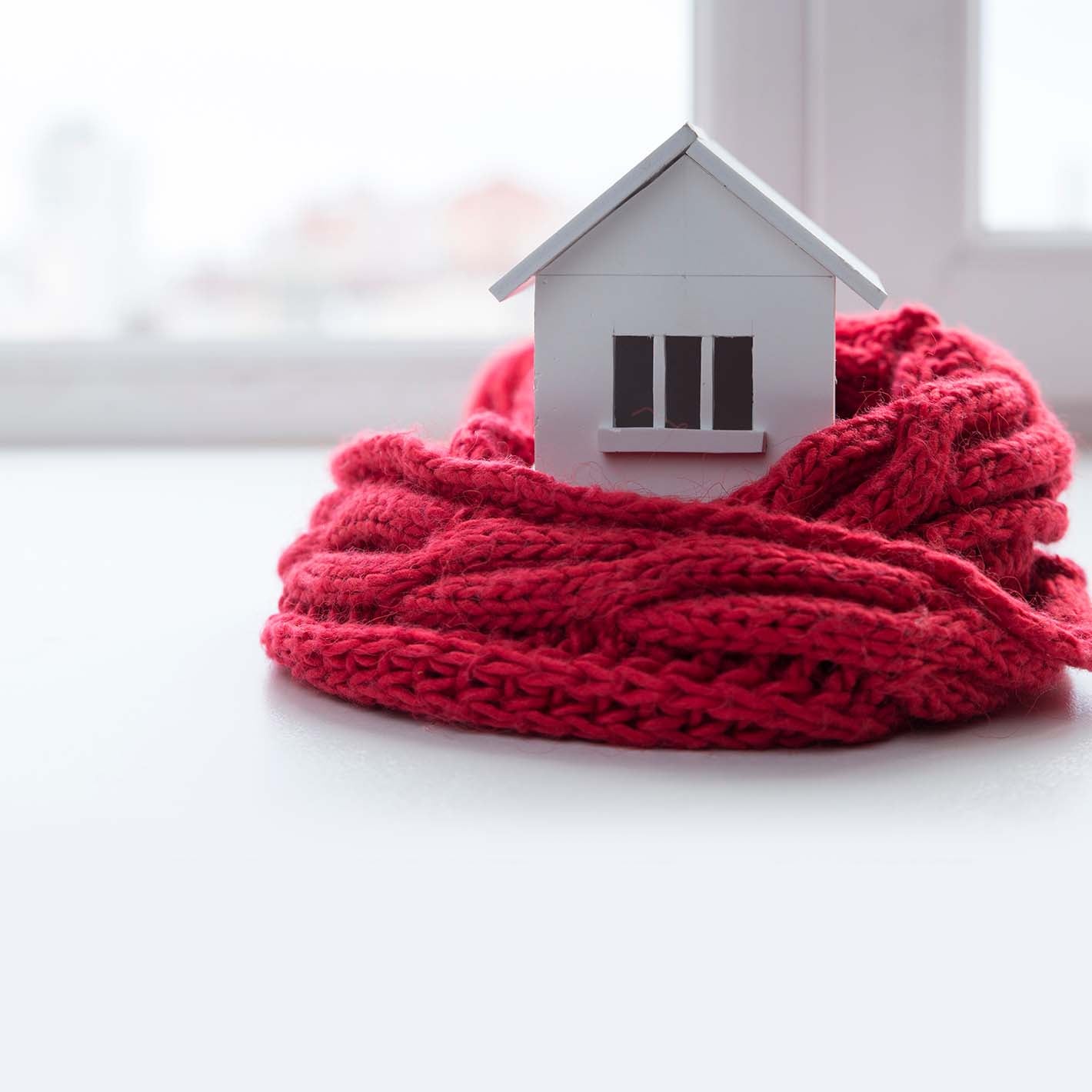 small wooden home wrapped in red scarf