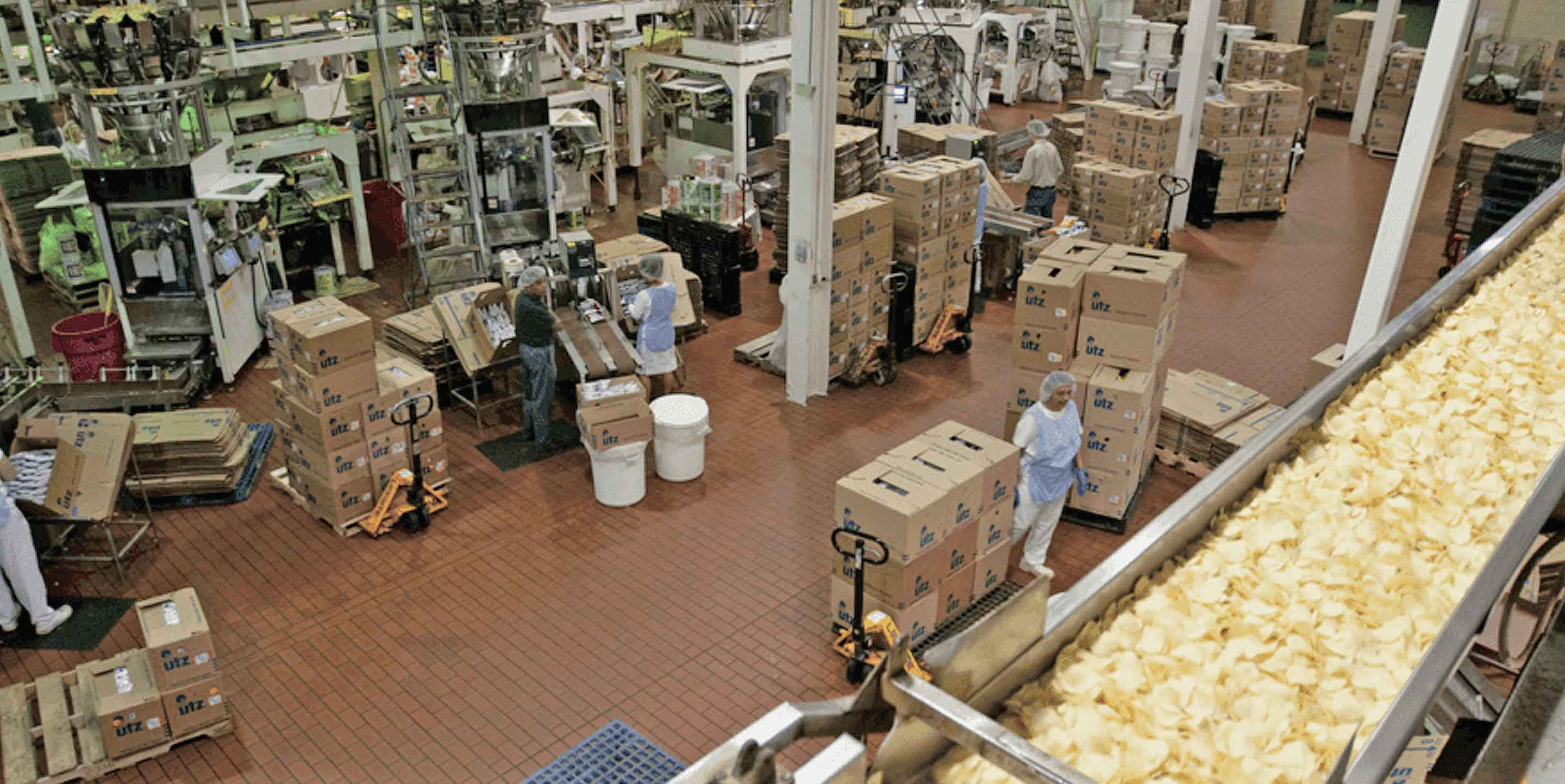 interior of UTZ factory showing workers boxing chips near conveyor belt