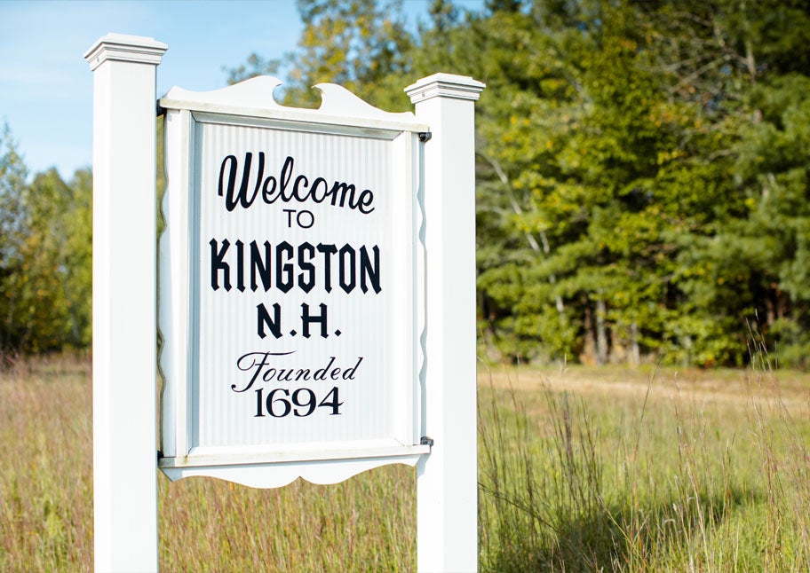 Kingston, NH, town sign with trees and grass in background