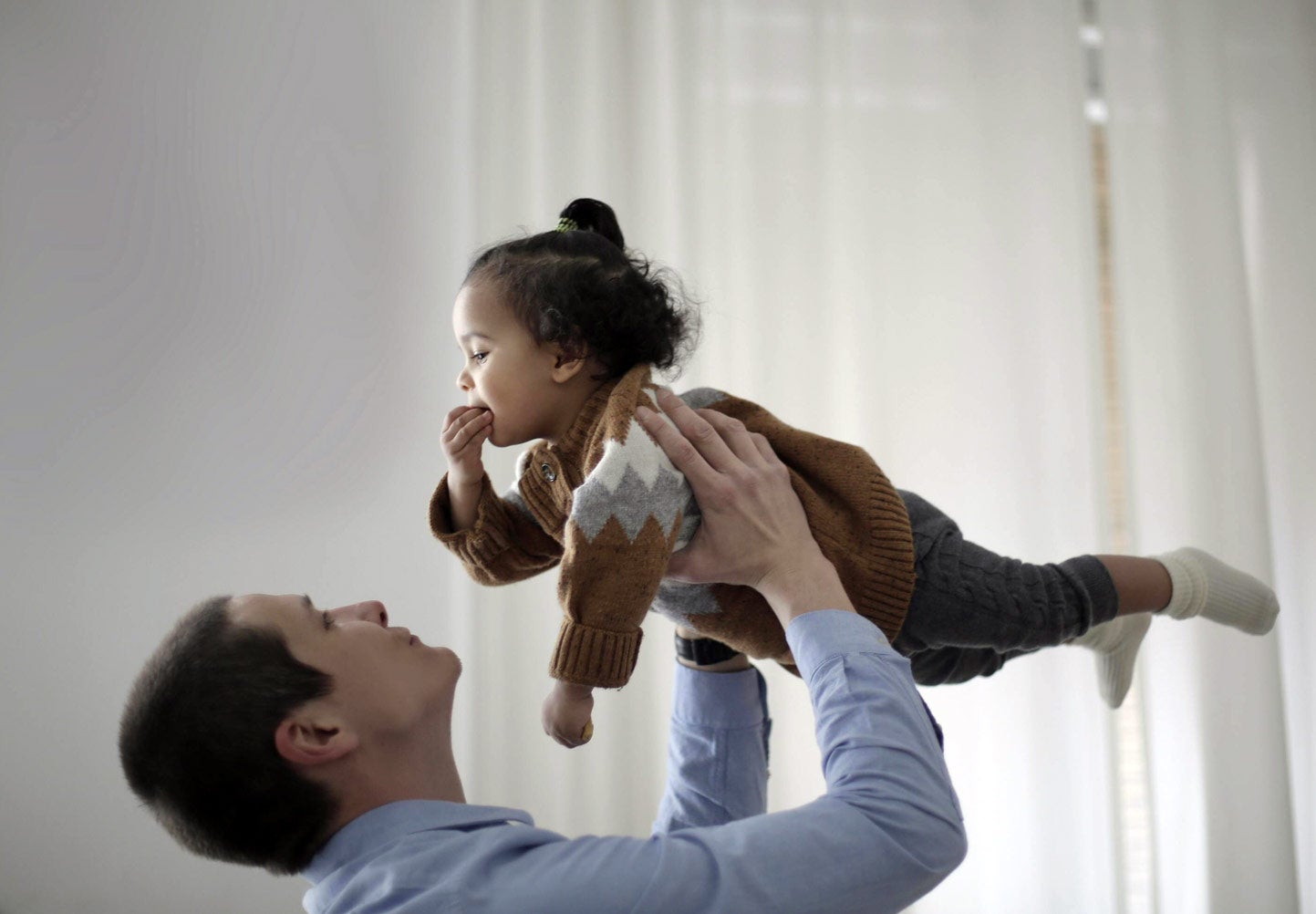 Man holding baby in the air