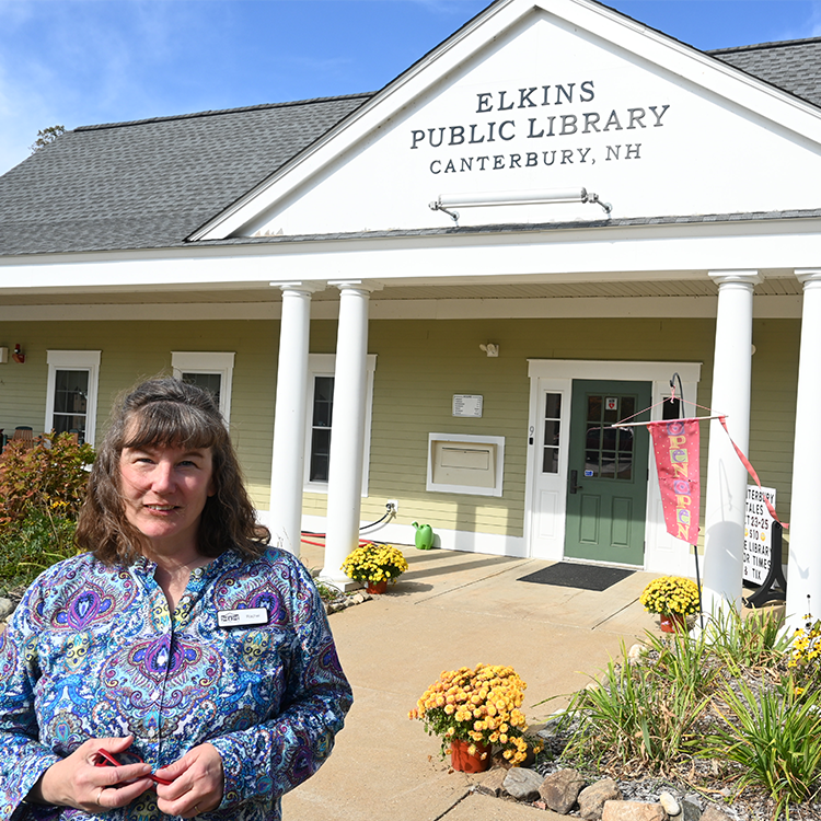 Rachel Baker, Elkins Public Library Director, stands in front of the exterior of the library