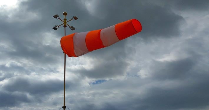 wind sock blows with dark clouds in background