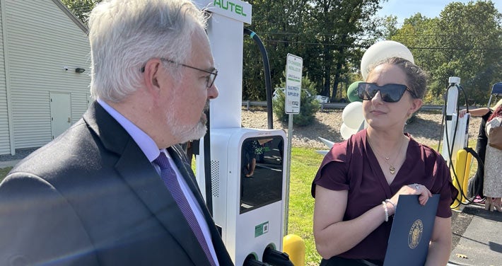Unitil employees at a ribbon cutting for a Level 2 EV charging station
