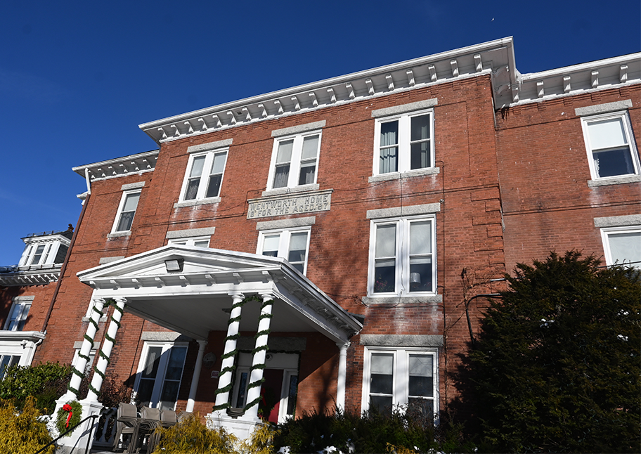 Wentworth Home in Dover, NH decorated for the holidays in front of deep blue sky