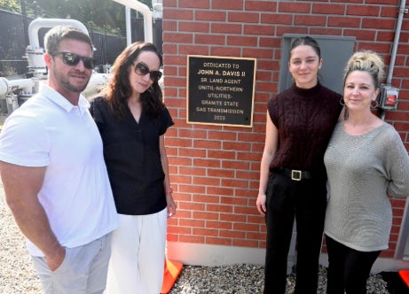 attendees with plaque at dedication ceremony