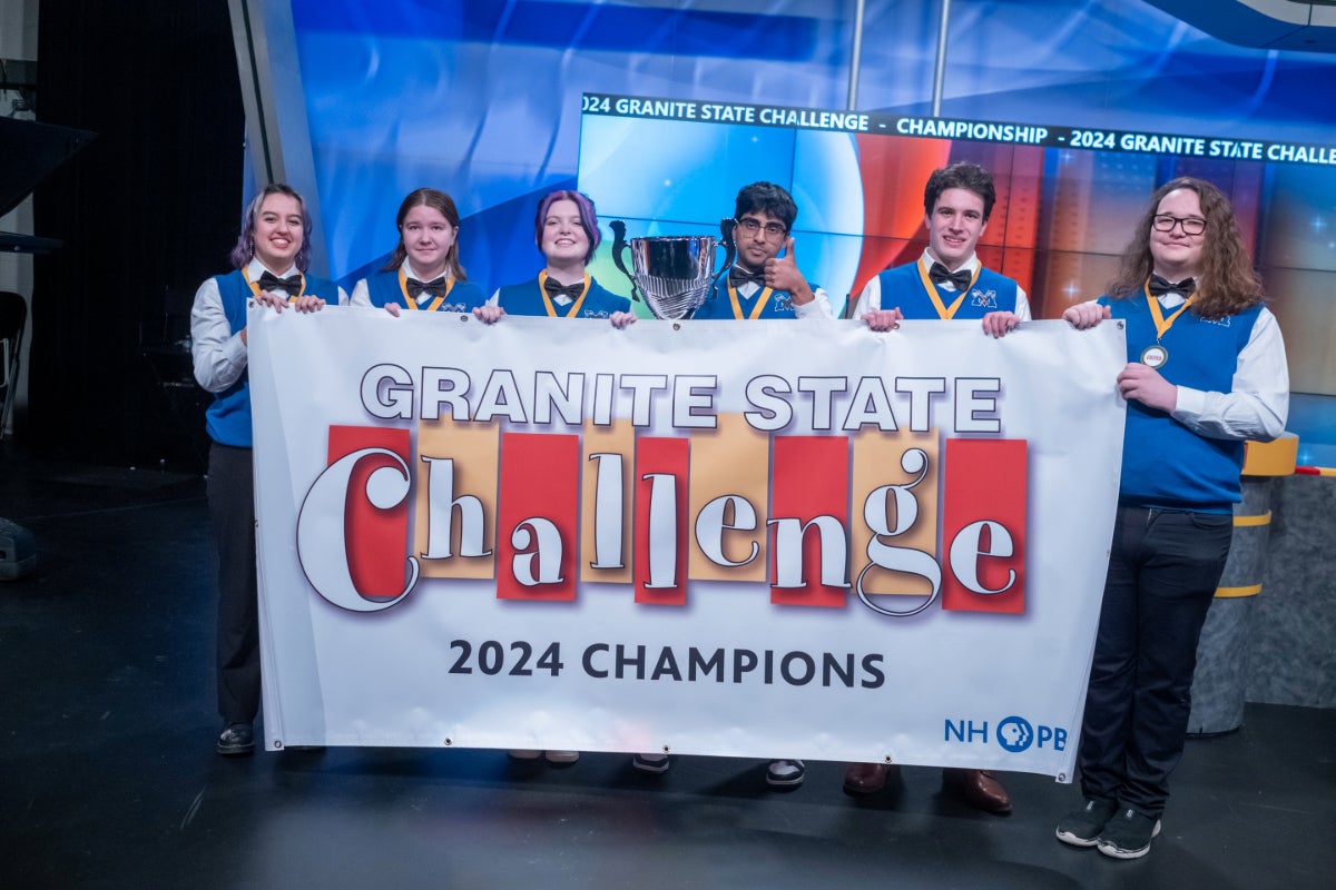 Winning team from Merrimack holding Granite State Challenge 2024 Champions banner.