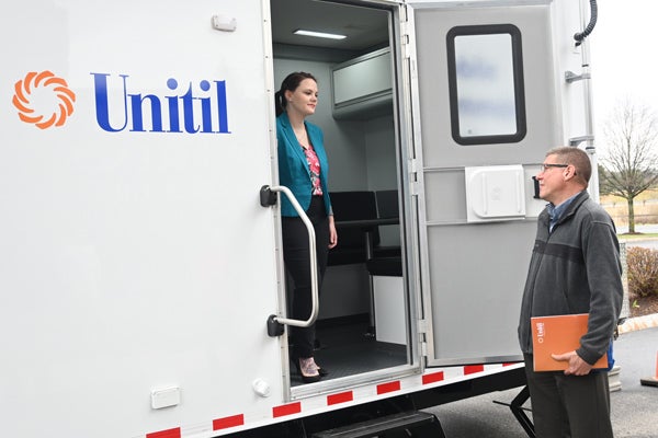 employees discuss opportunities at entrance of new mobile command center