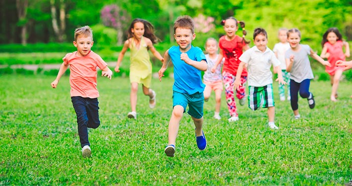 group of kids running through grass