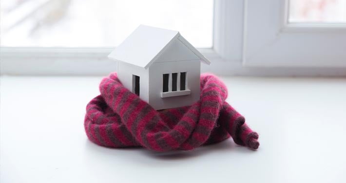 small wooden home model wrapped in a scarf