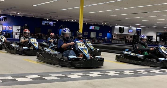 go-kart racers cross the finish line at the NH Motorplex indoor track