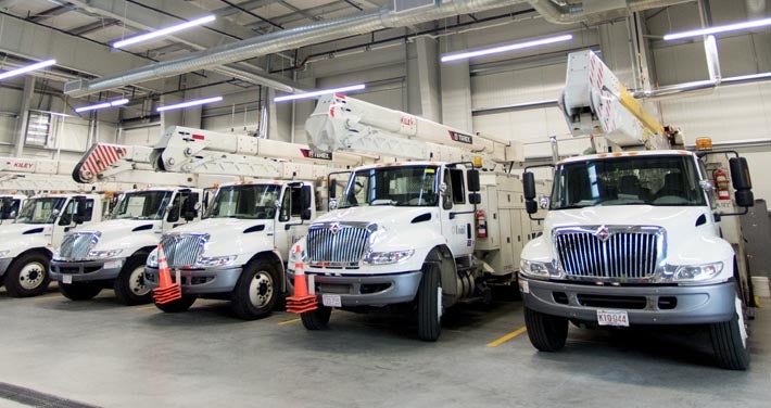 Unitil electric trucks lined up in warehouse