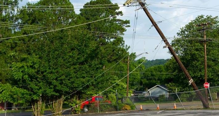 damaged utility pole tilting with wires drooping to ground