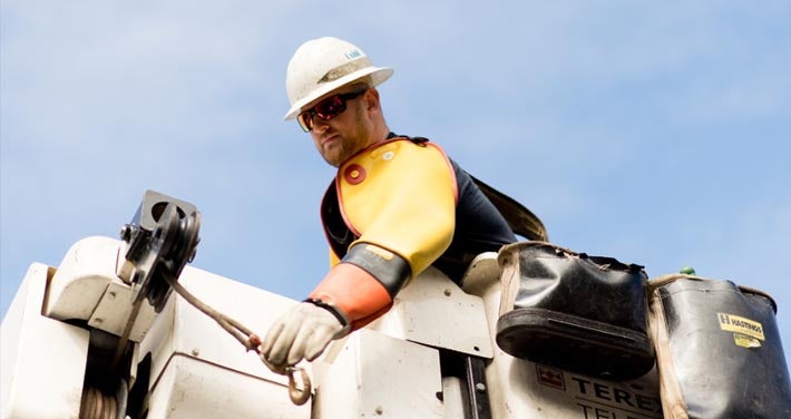 closeup view on Unitil line worker in bucket with sky background