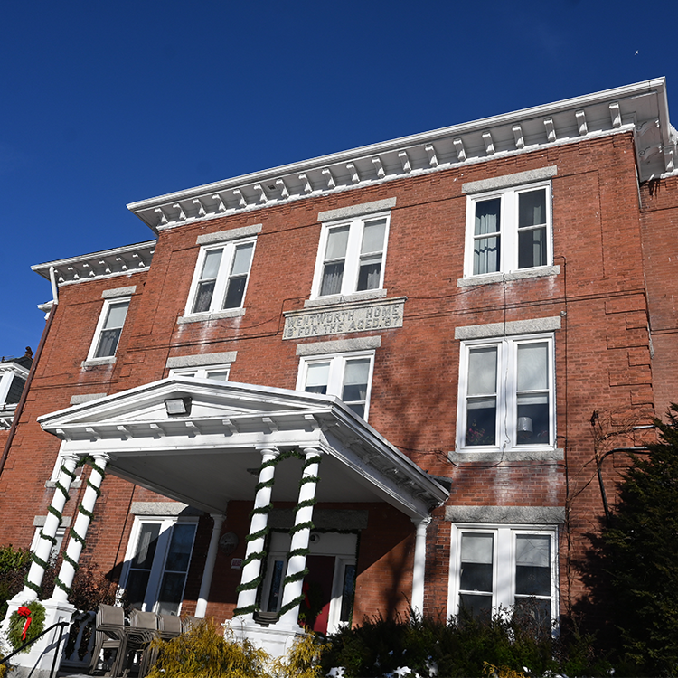 Wentworth Home in Dover, NH decorated for the holidays in front of deep blue sky