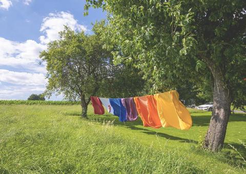 colorful clothes drying on clothesline between two trees
