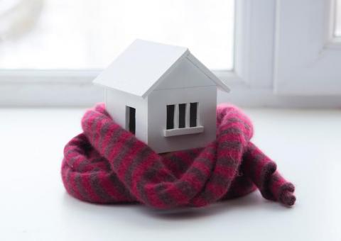 small wooden home model wrapped in a scarf