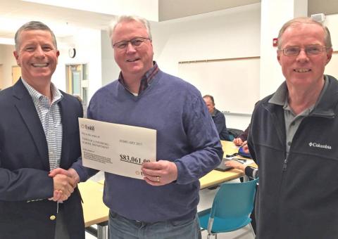 Unitil and Lunenburg School officials pose with a rebate printout