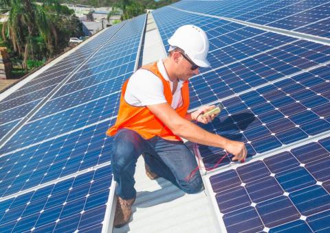 worker checking solar panel