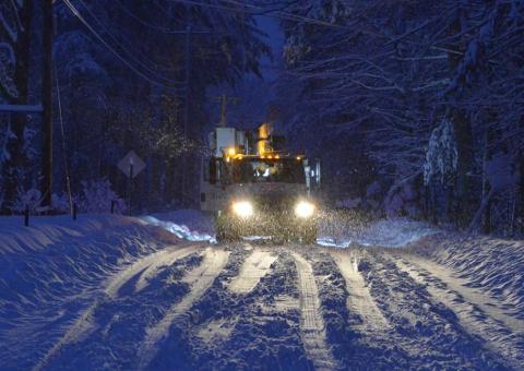 Unitil truck on snowy road at night