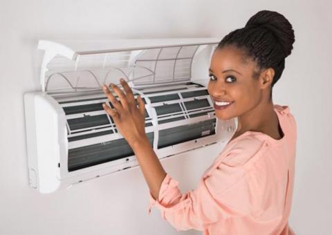 woman opening air conditioner at home