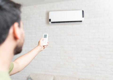 Man with a remote control for a heat pump