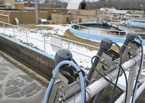 view of wastewater plant showing equipment in foreground and facility in background