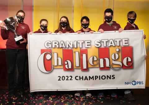 Portsmouth High School's Granite State Challenge team holds trophy in front of Champions banner