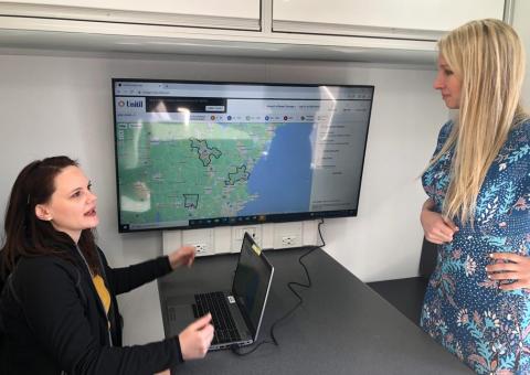 two women review the outage map at mobile command center desk