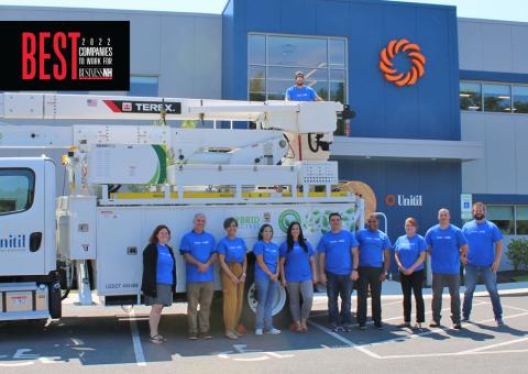 Unitil workers stand in front of hybrid truck at entrance of Unitil's Exeter facility