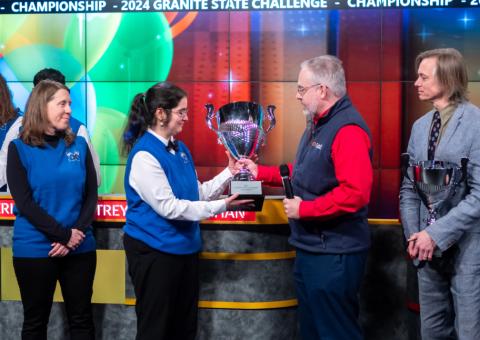 Alec O'Meara hands trophy to Granite State Challenge winner.