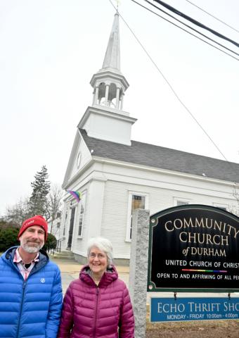 Church with people standing next to sign