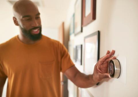 person adjusting thermostat