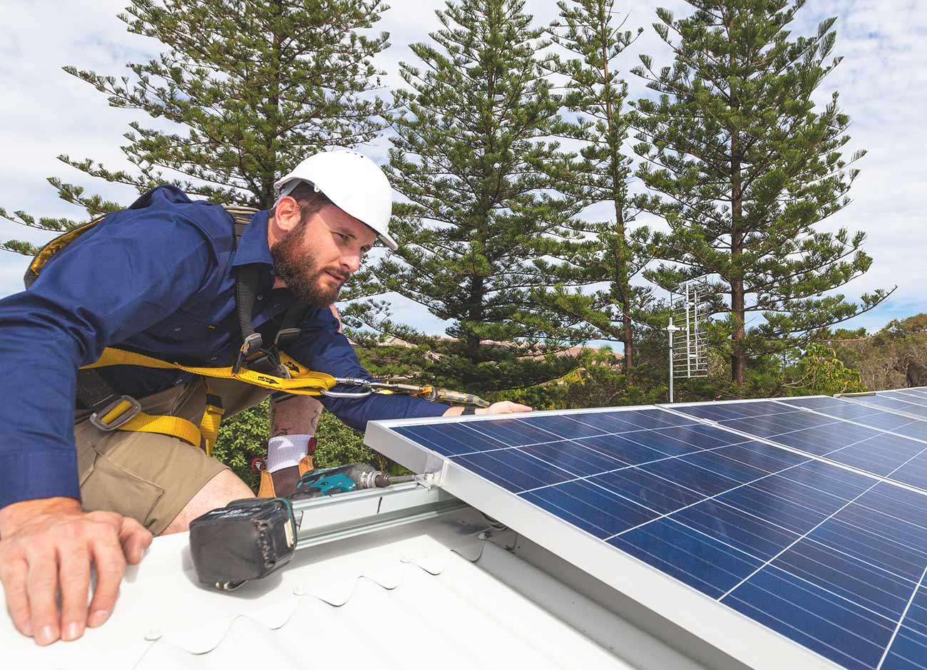 solar installer with panel on roof